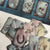 Discover the Curiosi-Tea Oracle Kit – a compact and enchanting tool for tea leaf divination. This unique set includes 18 thoughtfully designed cards, each adorned with symbolic imagery to guide your readings. Accompanied by a selection of charms, the kit offers a tactile dimension to your divination practice. Housed in a sleek gold tin, it’s perfect for on-the-go insights or intimate sessions at home. 