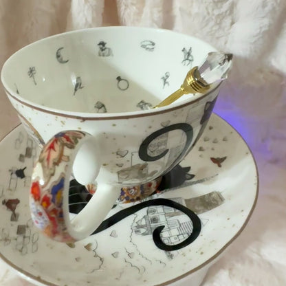 Handcrafted teacup featuring a cat dressed as a fortune teller, holding a crystal ball. Full tea leaf reading kit with free course. Perfect gift.