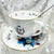 Close-up of the Alice in Wonderland punk teacup featuring bold, artistic illustrations