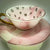 Video showcasing a pink marble effect teacup and saucer set, rotating to display the gold handle and internal fortune telling symbols.