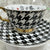 Alice in Wonderland teacup and saucer set with gold accents, accompanied by a matching teaspoon and tea samples, perfect for tea leaf reading and divination