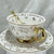 Luxury gold-accented teacup with permanent Tasseography symbols inside, including astrology symbols and a gold verse, perfect for tea leaf reading and divination.
