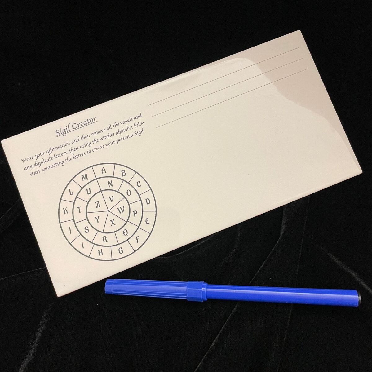 Ceramic Sigil Creator tile shown at an angle on a wooden surface