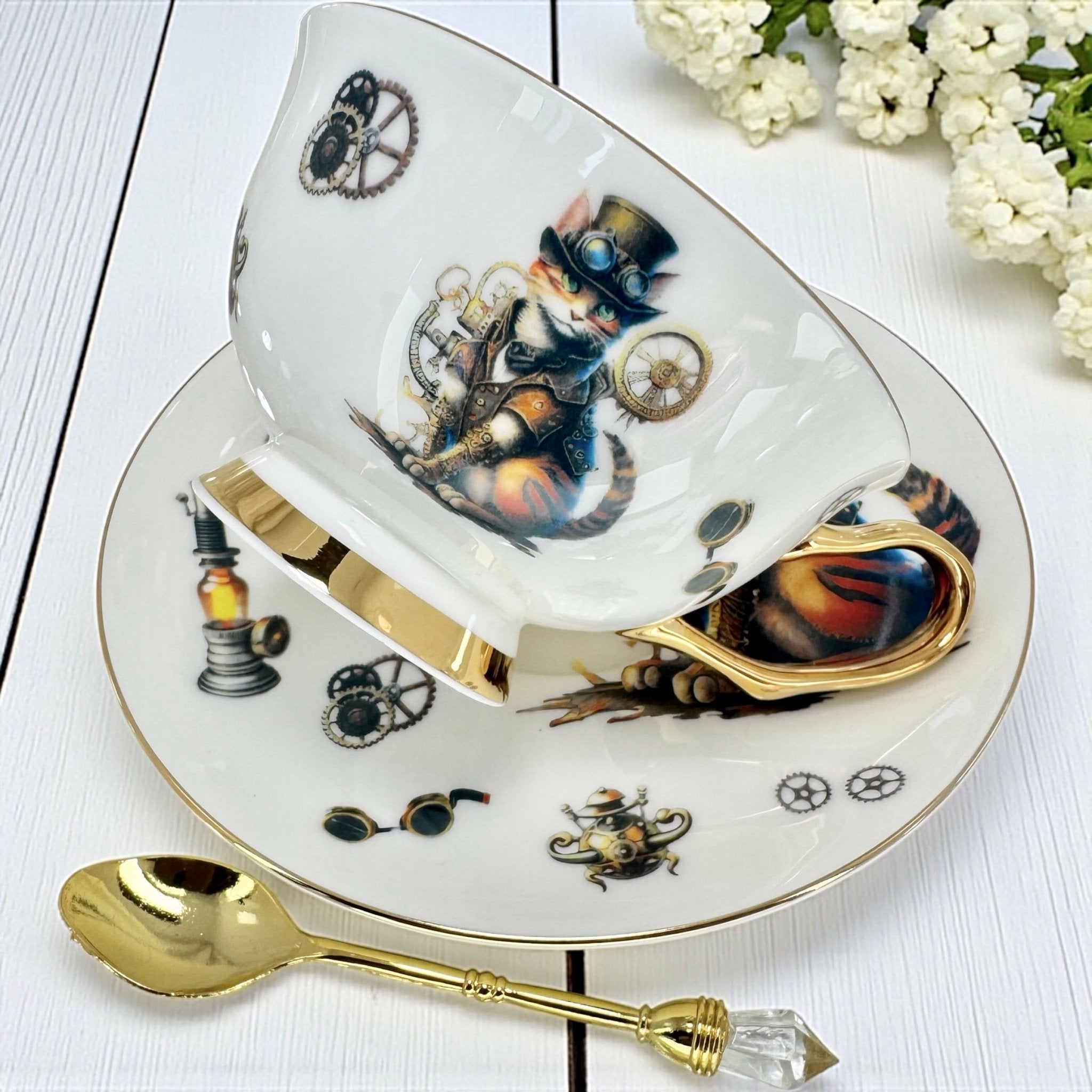 A top-down view of a white porcelain teacup and saucer. The teacup is tipped on its side, revealing the inside which is decorated with many small icons like a crescent moon, a coffin, and a cross. A gold spoon is in the foreground.
