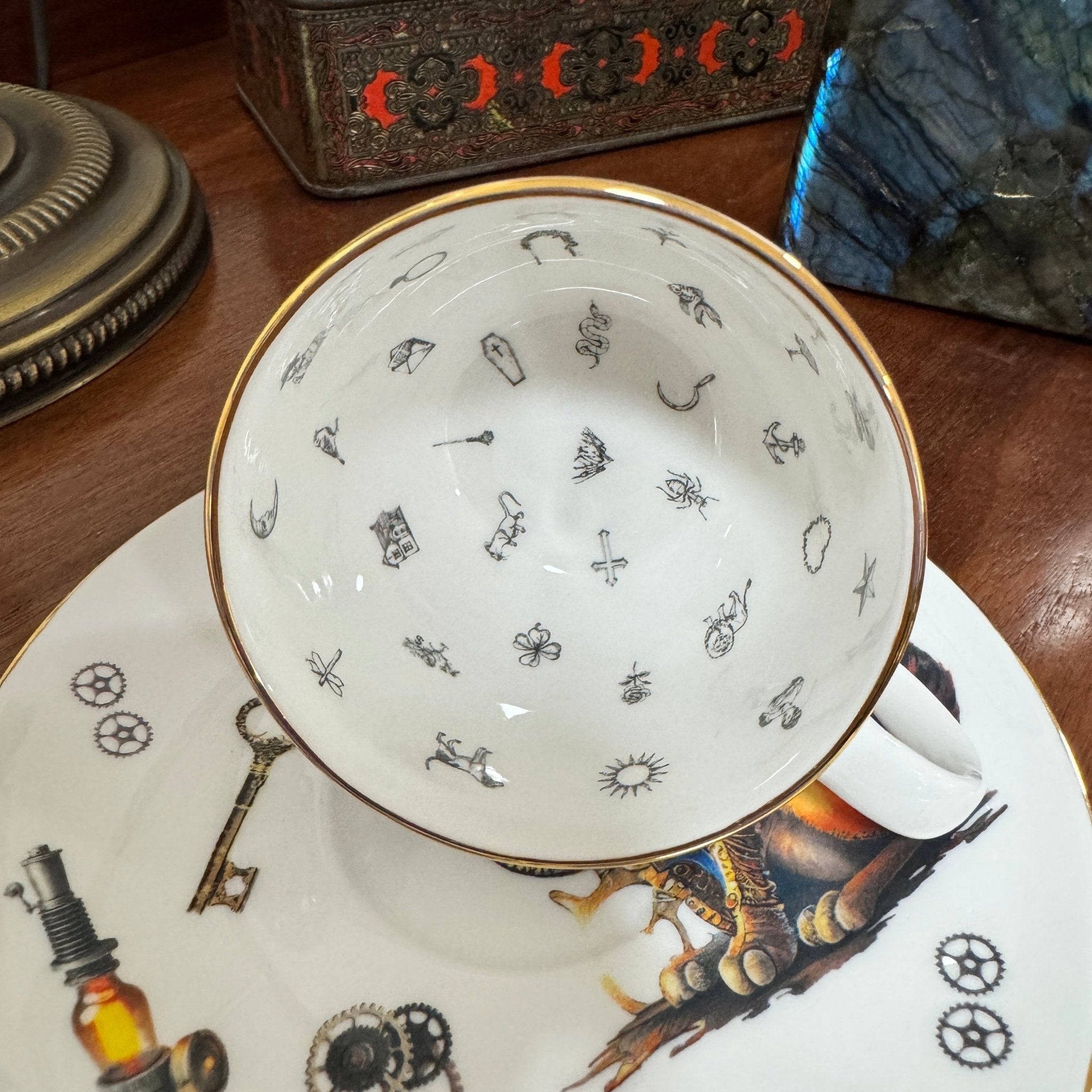 Teacup with decorative patterns on a matching saucer on a wooden surface.