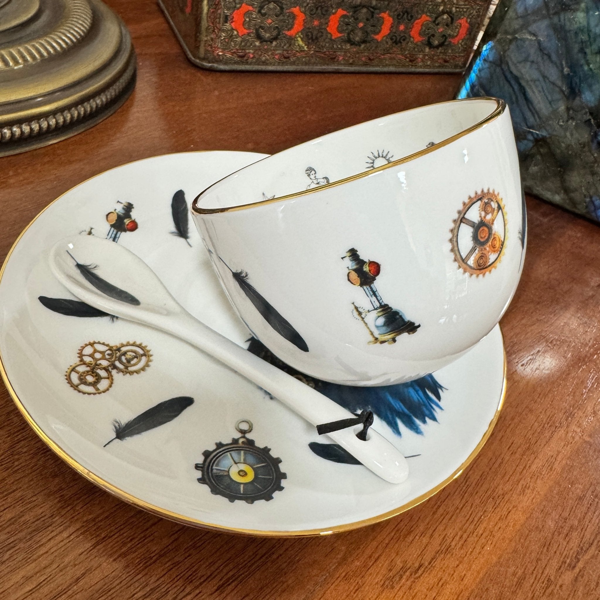 Decorative teacup and saucer set with intricate designs on a wooden surface