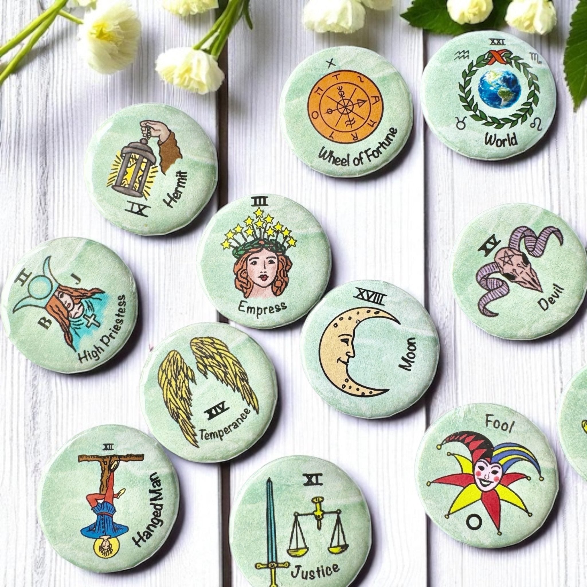 Set of 1-inch tarot buttons featuring the Major Arcana images on a pale mint green background, protected by a clear plastic coating, ideal for tarot, charm casting, and discreet divination in everyday settings