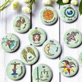 Set of 1-inch tarot buttons featuring the Major Arcana images on a pale mint green background, protected by a clear plastic coating, ideal for tarot, charm casting, and discreet divination in everyday settings