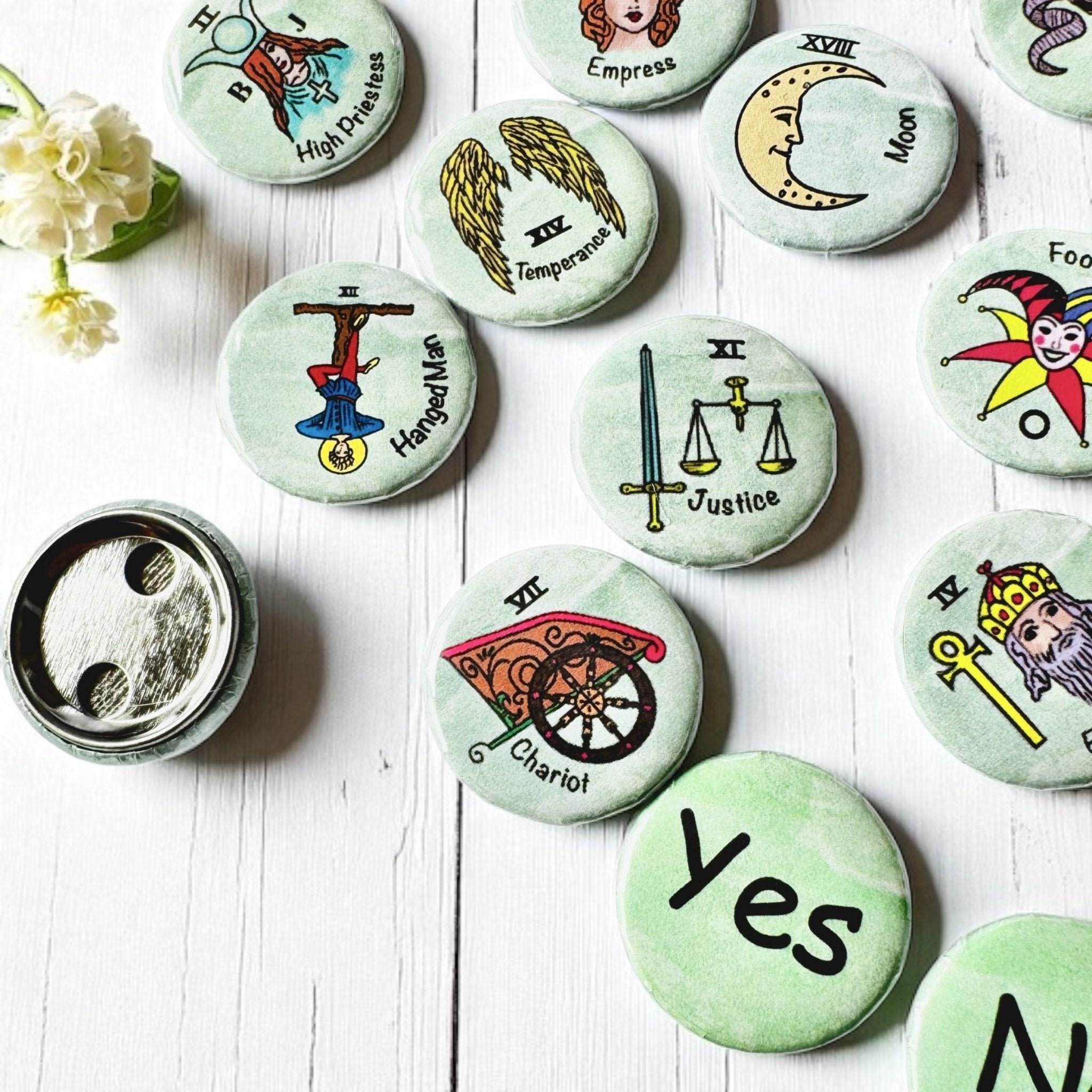 Set of 1-inch tarot buttons featuring the Major Arcana images on a pale mint green background, protected by a clear plastic coating, ideal for tarot, charm casting, and discreet divination in everyday settings