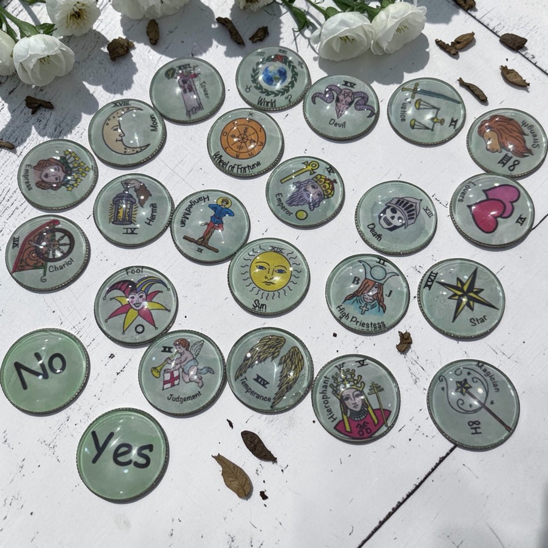 Complete set of 22 Major Arcana tarot charm casting coins with hand-drawn designs under glass dome tops and smooth metal backing plates displayed on a white surface
