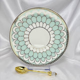 Porcelain saucer with mint green and white scalloped pattern, gold trim, displayed with an ornate gold teaspoon.