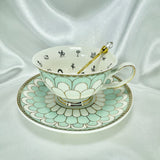 Overhead view of the porcelain teacup with black fortune telling symbols inside, sitting on a saucer with a gold spoon.