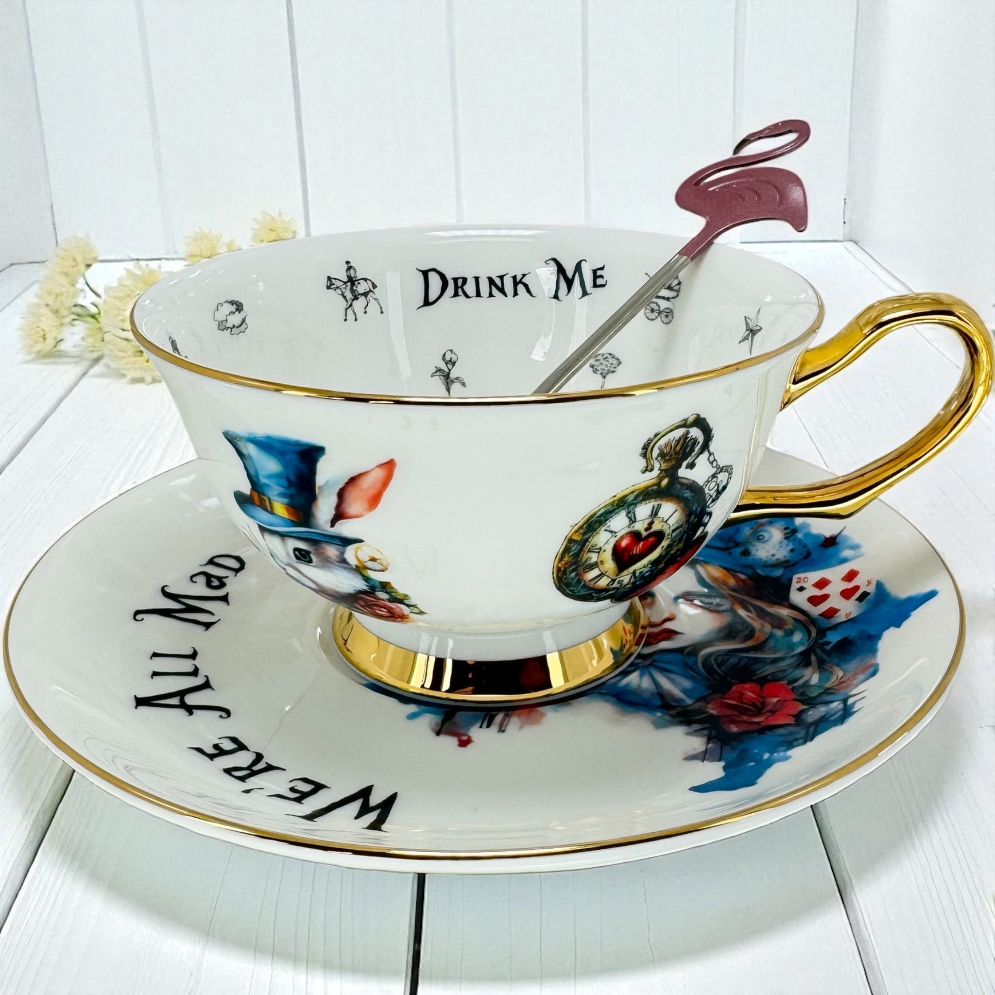Whimsical Alice teacup and saucer next to the Cheshire Cat's Guide.