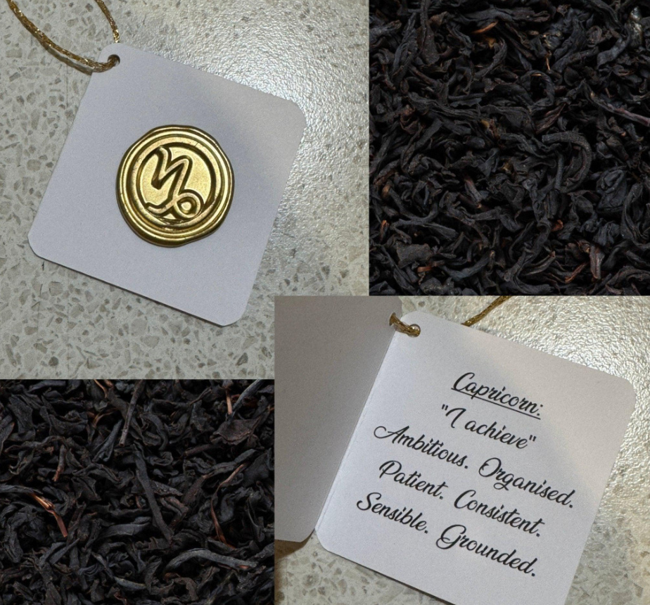 Gold wax seal zodiac tag for Capricorn, with the sign's motto and traits written inside, beside loose leaf tea