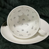 Luxury teacup with a heart-shaped design that appears when tea is poured, featuring permanent gold accents and intricate symbols inside, perfect for tea leaf reading and divination.