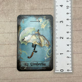 Tea leaf reading card deck with 45 high-gloss, 300gsm cards featuring unique symbols, a symbol dictionary, and a gold teaspoon, presented in a cotton drawstring bag